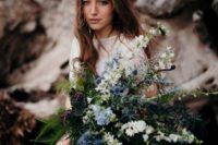 20 a moody bridal bouquet with white and blue flowers and leaves and greenery