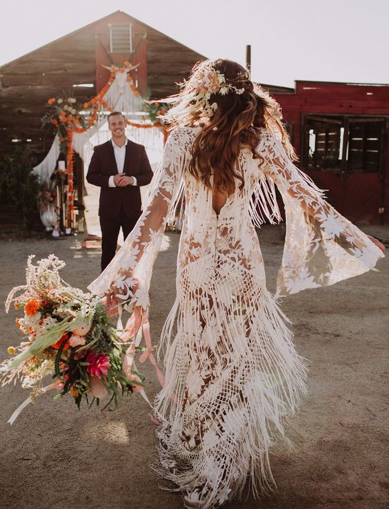 a boho lace wedding dress with bell sleeves and fringe for a free-spirited feel