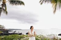 21 a lush tropical wedding arch of palm leaves and blush blooms lets enjoy a seascape
