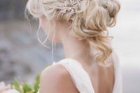 21 a wavy and messy updo with curls down and a sparkling rhinestone headpiece