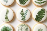 21 pretty glazed cookies with greenery of various kinds for a desert or botanical wedding