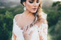 22 a glam bride wearing an embellished sash and oversized glam earrings with an off the shoulder dress