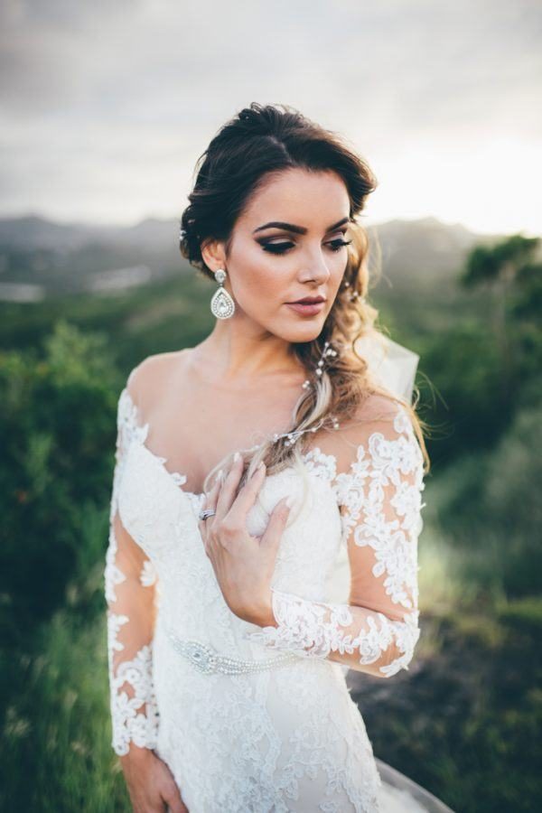 a glam bride wearing an embellished sash and oversized glam earrings with an off the shoulder dress
