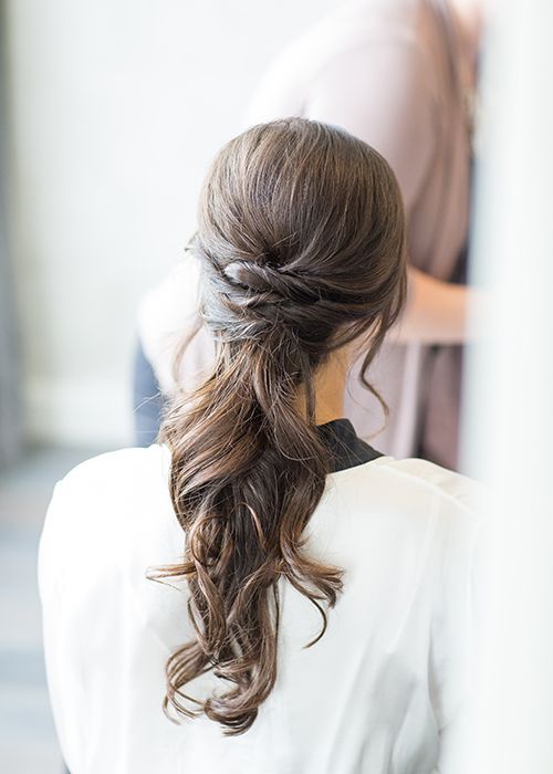 a low twisted ponytail with some wavy locks down and wavy ends is a chic and casual idea