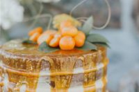 22 a naked wedding cake with honey drip and kumquats for a bold summer wedding