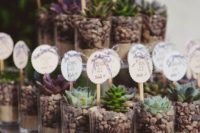 22 succulent wedding favors with pebbles and sand and various tags as escort cards