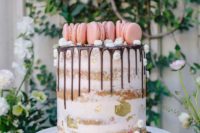 24 a semi-naked cake with gold foil and topped with pink macarons on top plus small meringues