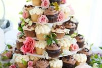 26 serve cupcakes on a stand decorated with greenery and fresh blooms to make the stand feel garden-like