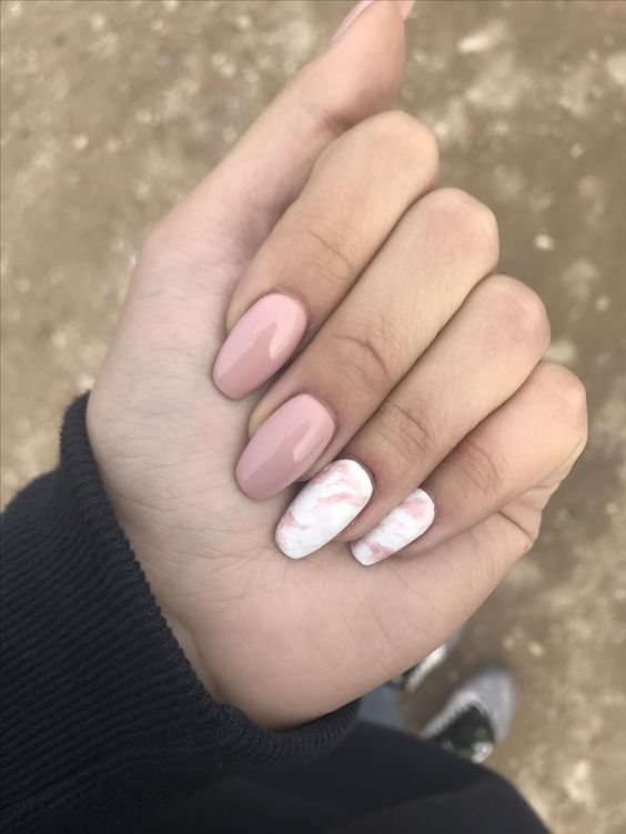dusty pink nails and two white and dusty pink marble nails that bring a trendy and edgy feel to the look
