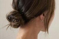 a chic and cool messy low bun with a bump on top and face-framing locks is a cool hairstyle for medium hair