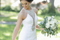The bride was wearing a fantastic vintage sheath wedding gown with an embellished illusion neckline and statement earrings