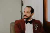 02 The groom was wearing an elegant burgundy suit with a black bow tie and brown shoes