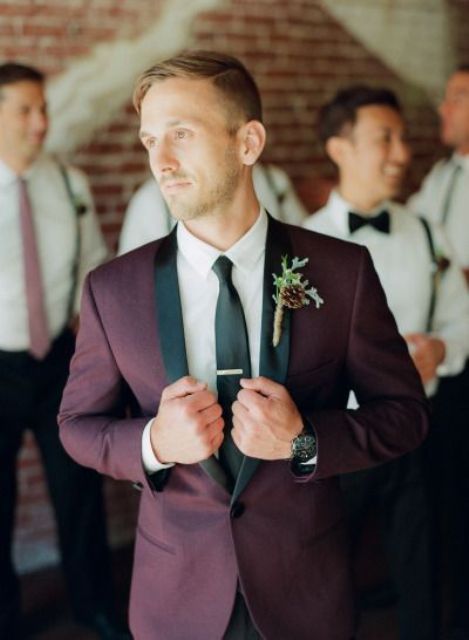 a burgundy tuxedo with black lapels and a black tie for a colorful touch