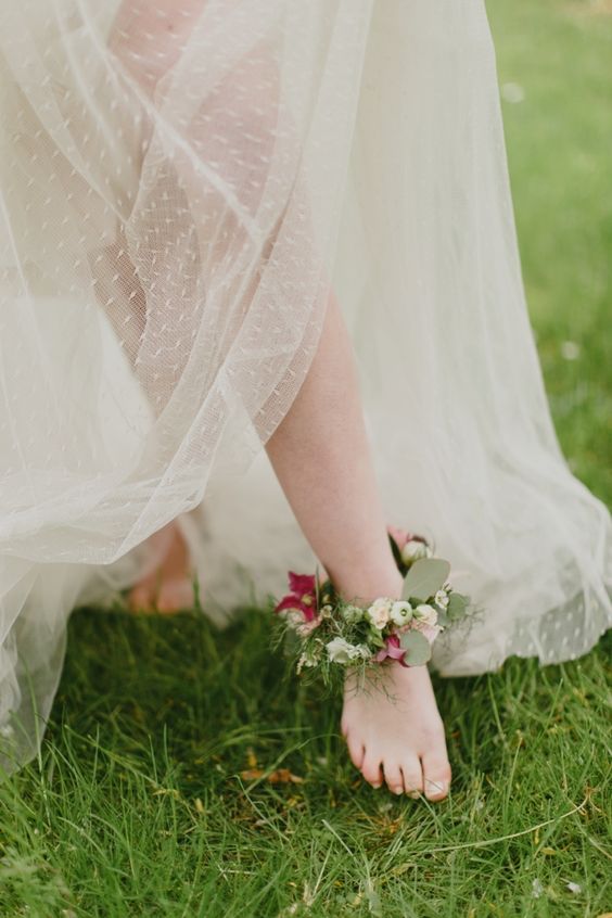 a floral anklet with plum colored blooms and greenery for a garden bride