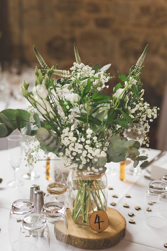 a refreshing greenery and floral centerpiece with lily of the valley for a rustic summer wedding