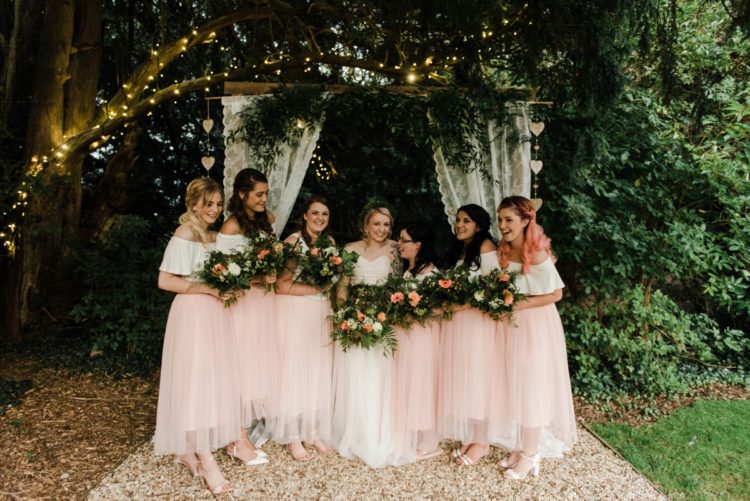 The bridesmaids were wearing white off the shoulder tops and pink tulle midi skirts