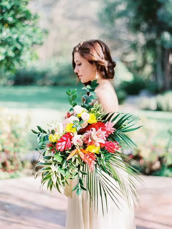 a bold bouquet with tropical leaves, red and yellow blooms and an eye-catchy shape