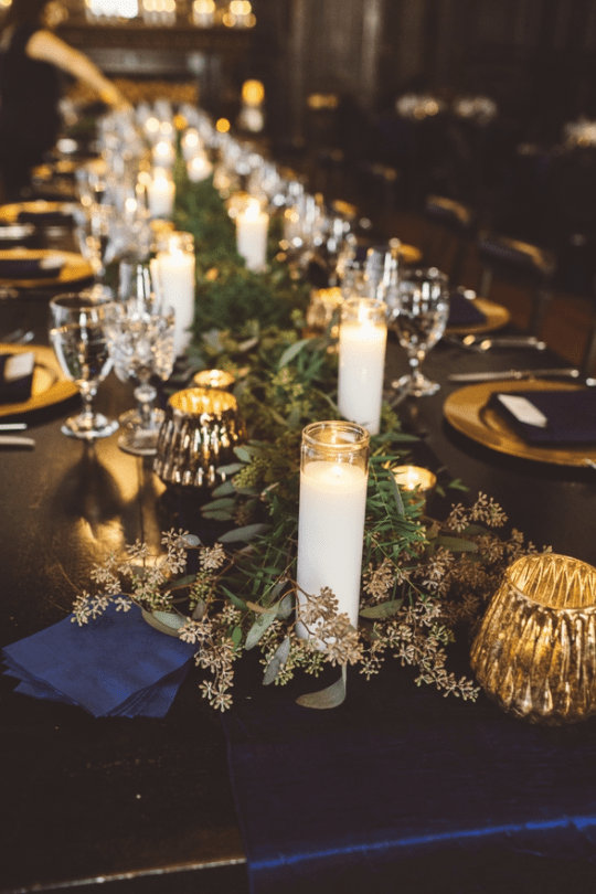 Lush eucalyptus table runners enlivened the tables and pillar candles created a cozy ambience