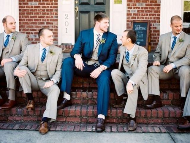groomsmen dressed up in three-piece suits and bold blue ties for a contrast