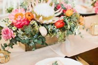 09 a box centerpiece with pink and red blooms, greenery, succulents and a king protea