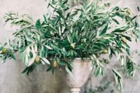10 an elegant olive branches and olive centerpiece in a vintage urn for a chic Italian wedding