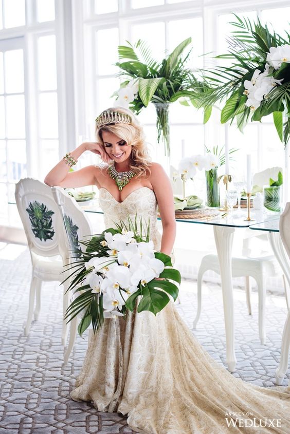 an elegant tropical wedding bouquet with white orchids and tropical leaves for a glam wedding