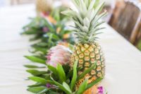 12 a tropical runner of greenery, king and pincushion proteas and pineapples for a cool look