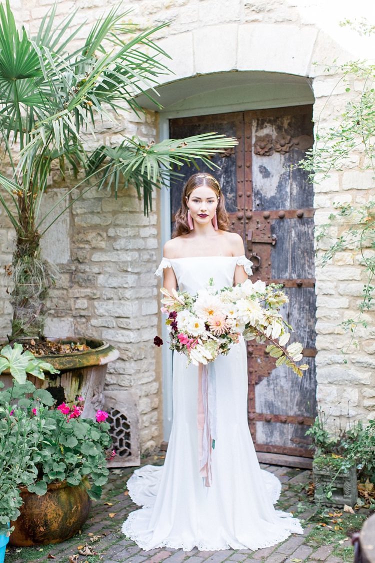 a plain fit and flare off the shoulder wedding dress with lace detailing and small train