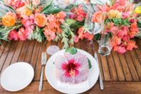 14 a bold tropical wedding table runner with orange and red blooms plus greenery and a large flower