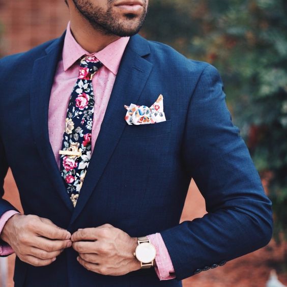 a colorful summer look with a navy suit, a pink shirt and a floral print tie for a dapper feel