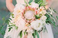 14 a delicate wedding bouquet with a king protea, white blooms and cascading greenry for a chic touch