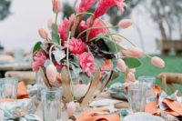 a fantastic metallic bowl centerpiece with pink tulips and tropical flowers for a dimensional look