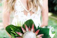 16 a laconic tropical bouquet with a single king protea and large tropical leaves