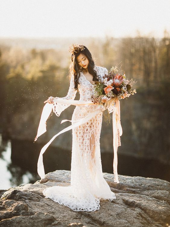 a boho lace sheath wedding gown with bell sleeves, a V-neckline and a front slit for a boho bride