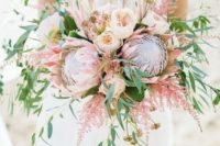 18 a lush bouquet with king proteas, blush peonies and lots of greenery and pink branches for a tender look