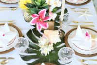 18 a palm leaf table runner with bold tropical blooms and gilded pineapples for a bold tropical look