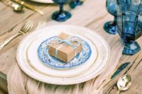 18 an airy taupe wedding table runner matches the table itself and a box and everything is spruced up with bright blue touches