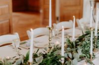 20 a chic textural foliage table runner with tall candles in gilded candle holders