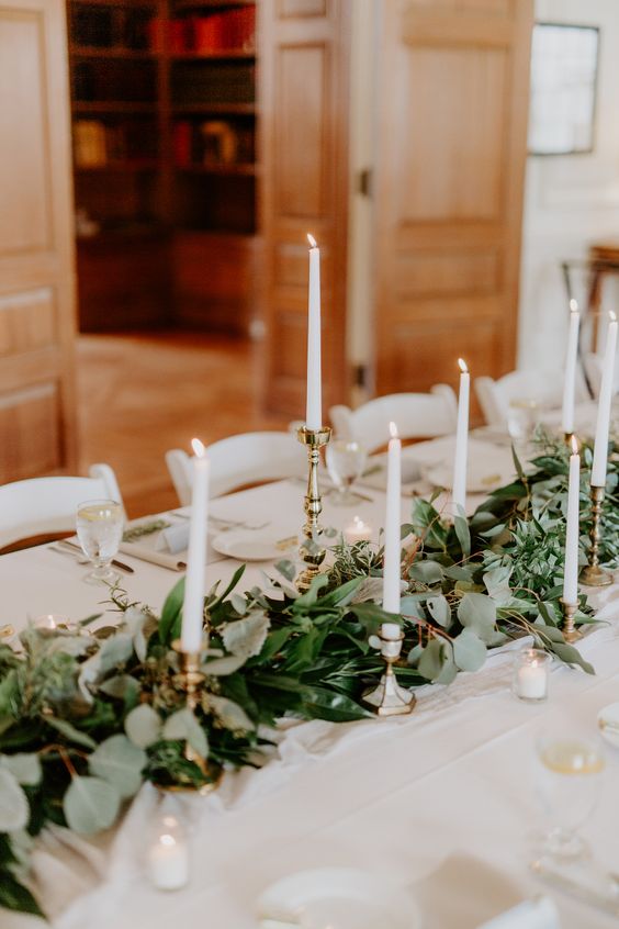 a chic textural foliage table runner with tall candles in gilded candle holders
