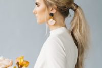 21 a modern sleek low ponytail with a small bump and textural ends is ideal for a minimalist bride