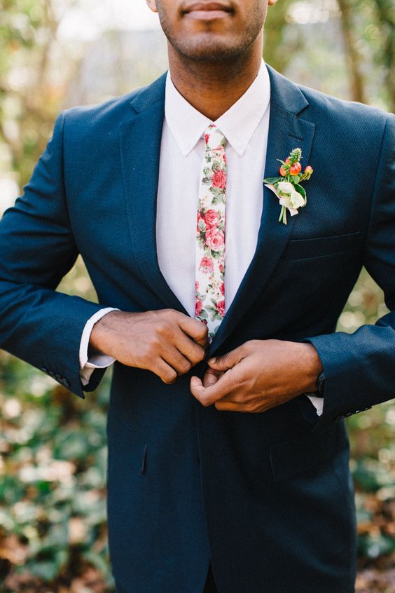 a navy suit, a white shirt plus a pink florla print tie for a bright and cheerful summer wedding look