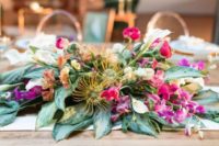 22 a textural and super lush centerpiece with pink and mauve blooms and greenery looks unusual