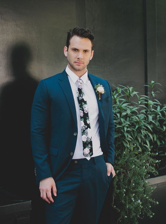 a teal wedding suit, a white shirt and a dark floral print tie for a contrasting look