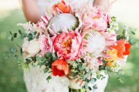 25 a vibrant wedding bouquet with king proteas, pink and orange blooms and greenery for a summer wedding