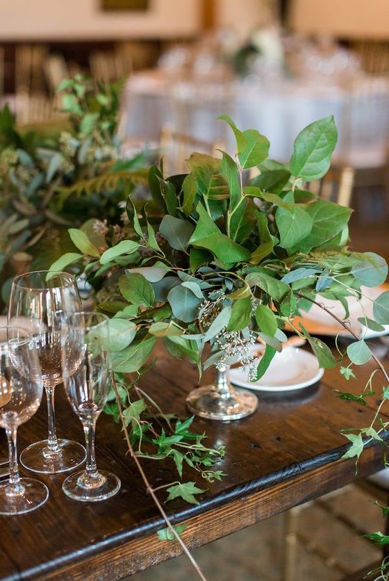 a beautiful wedding centerpiece of a silver bowl and an arrangement of lush textural greenery for a refined wedding