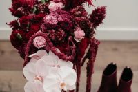 a bold and catchy wedding bouquet of pink roses, white orchids, amaranthus and burgundy pampas grass is wow