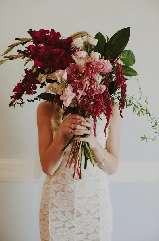 a bright wedding bouquet of blush and pink blooms, burgundy blooming branches, leaves and amaranthus is amazing for a tropical bride