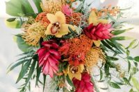 a cascading tropical wedding bouquet with fuchsia, yellow, orange blooms and greenery