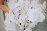 a cascading white wedding bouquet of orchids and baby’s breath is a beautiful and fresh solution for a sophisticated bride