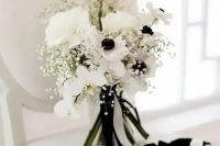 a chic black and white wedding bouquet of white orchids, roses and anemones, baby’s breath, some black and white ribbons